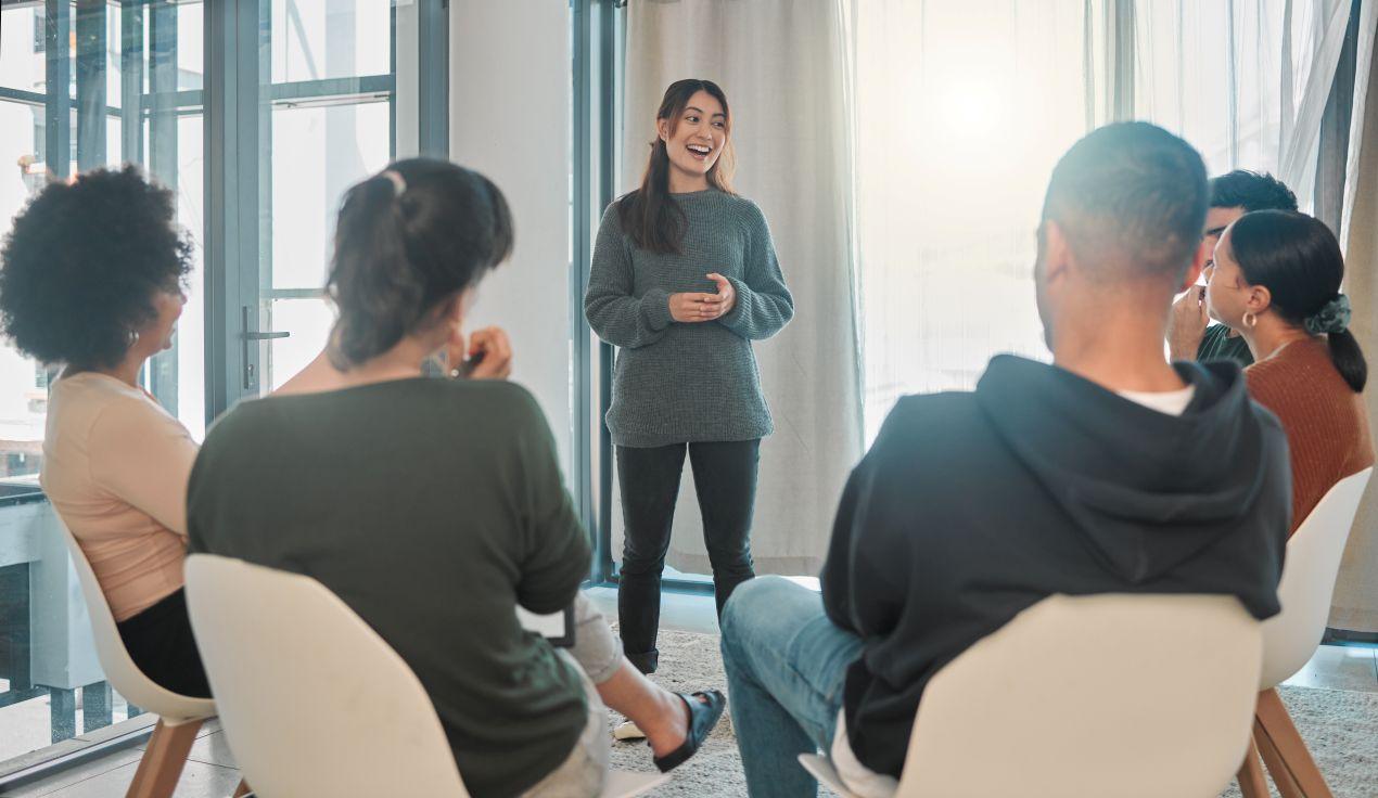 Eine Frau haelt einen interaktiven Workshop vor einem kleinen Team – ein Beispiel fuer wirksame Mitarbeiterberatung zur Foerderung der psychischen Gesundheit.