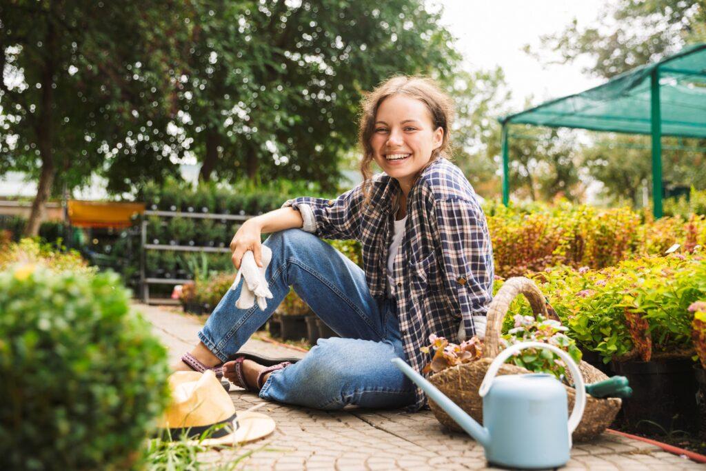 Gartenbau Heidelberg: Frau inmitten von Pflanzen mit Gartenwerkzeug