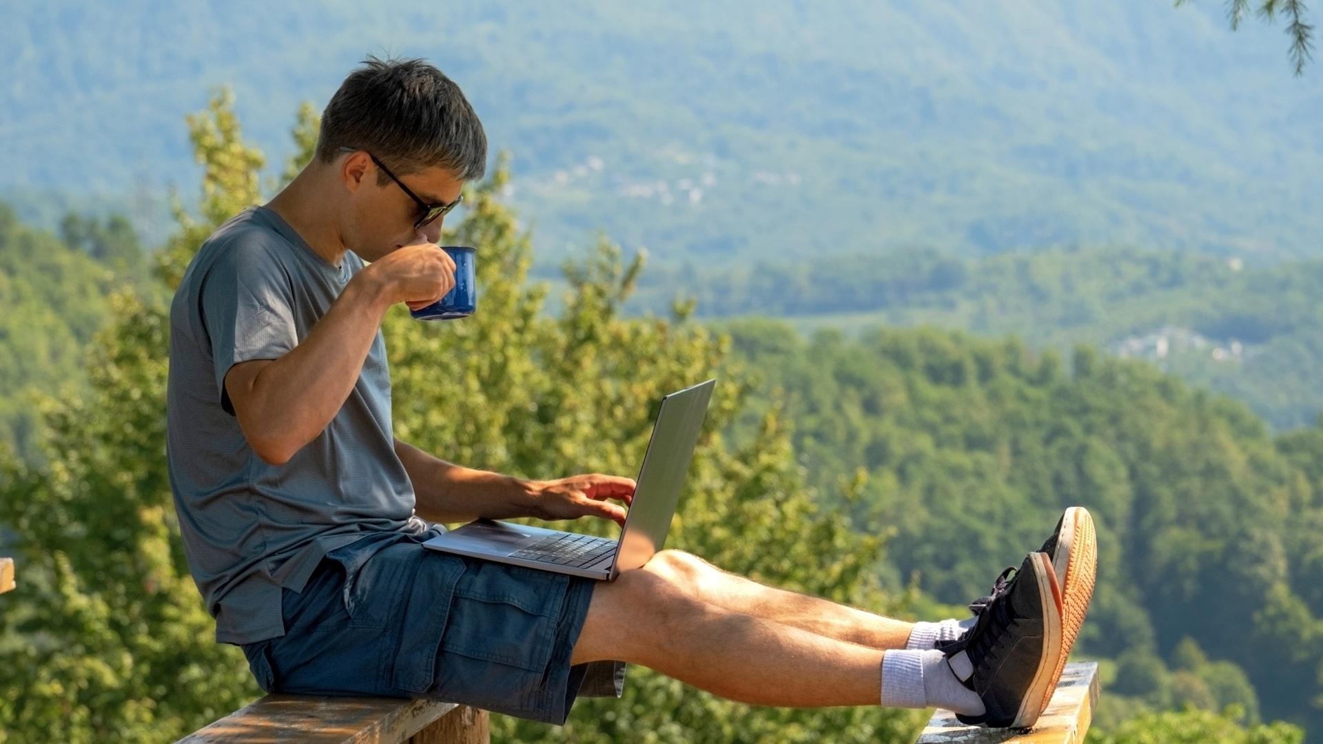 Mann arbeitet mit Laptop im Freien | Amazon Advertising Agentur