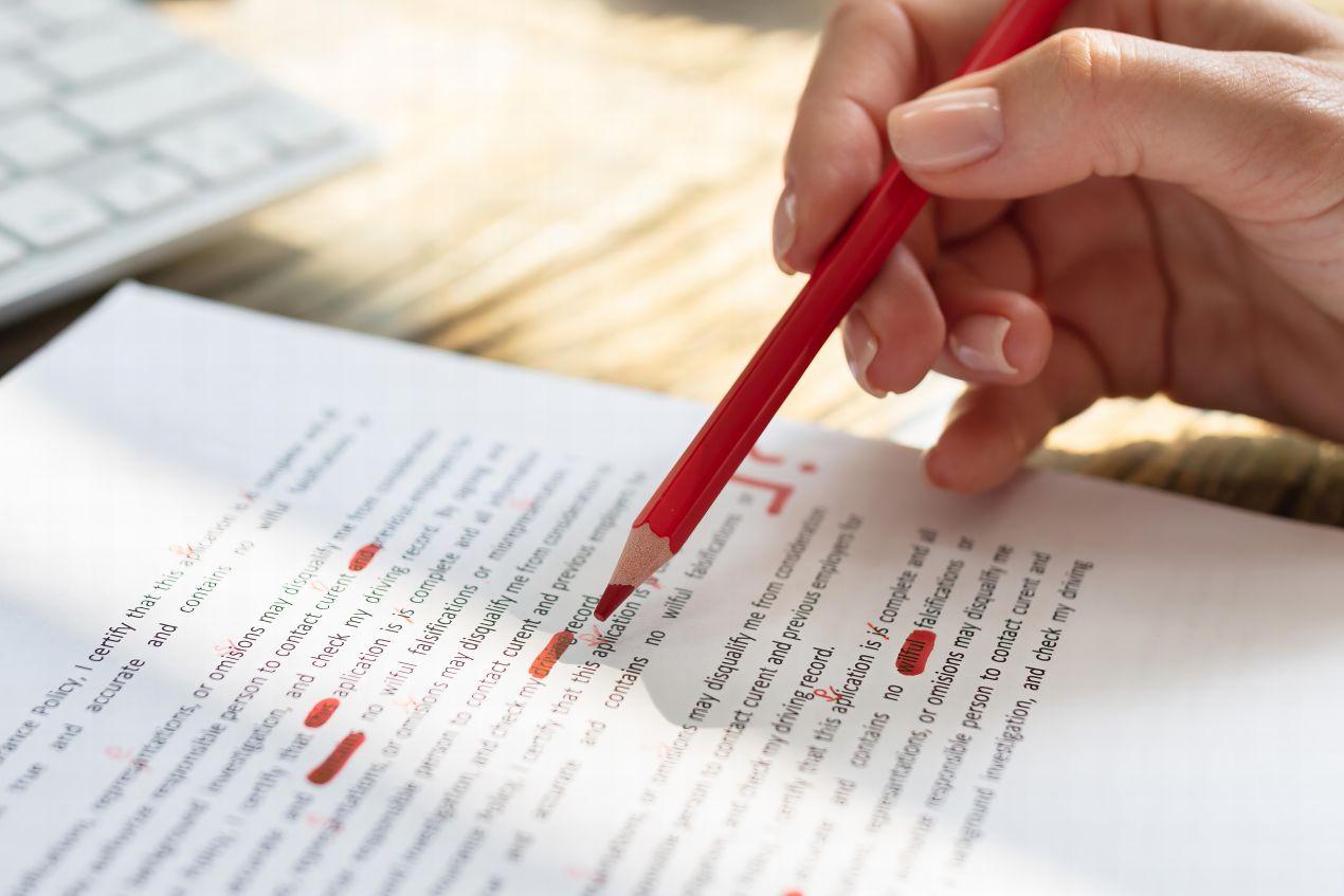 Hand korrigiert Text mit rotem Stift als Vorbereitung für das Lektorat
